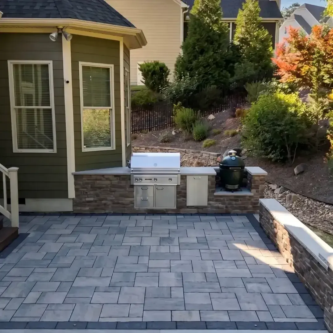 Paver patio with a built-in grill island and a ceramic smoker