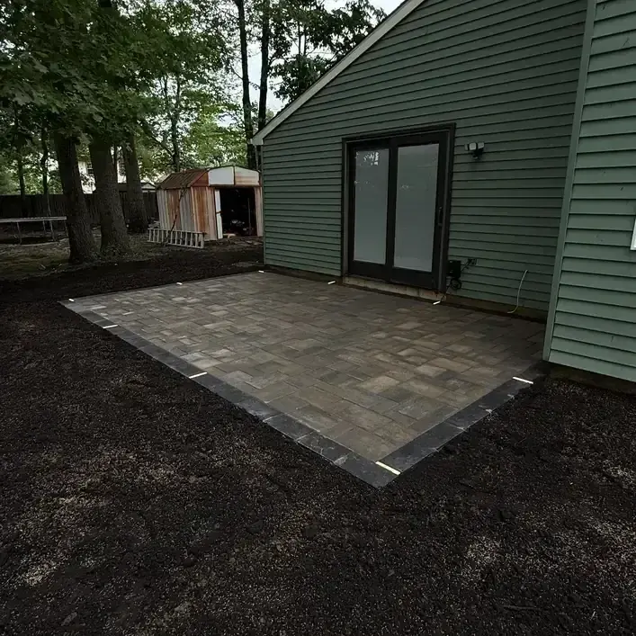 Newly installed paver patio behind a home