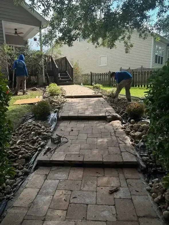 MC crew installing a stone walkway through a side yard