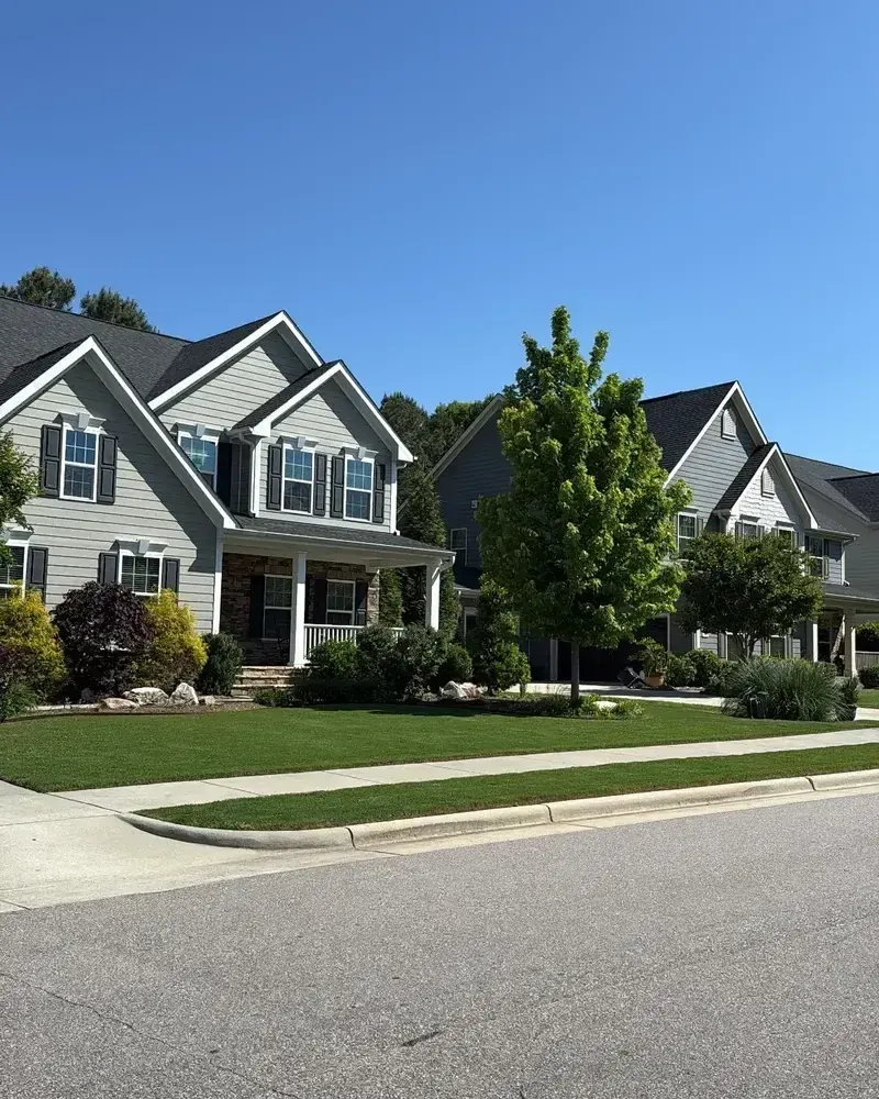 Two-story home with a manicured front lawn and planting beds