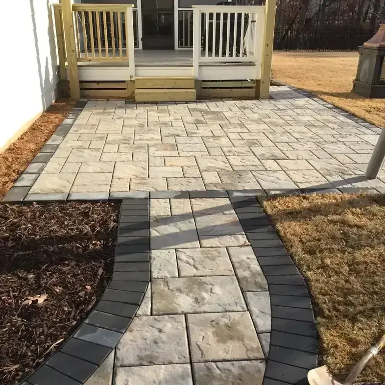 Paver patio connected to a curving paver walkway with a dark border